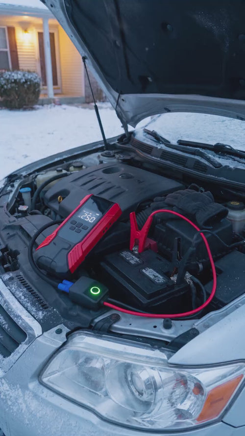 Illustrative animation: red jump starter clamped to a car battery on a snowy morning