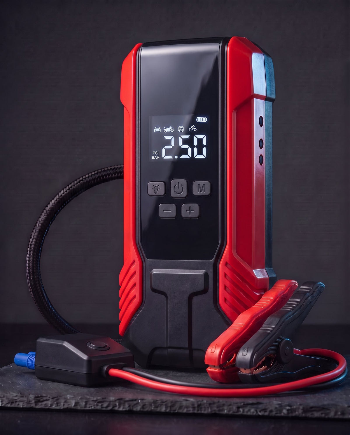 Illustration: red 12V jump starter with digital pressure display, clamps and air hose